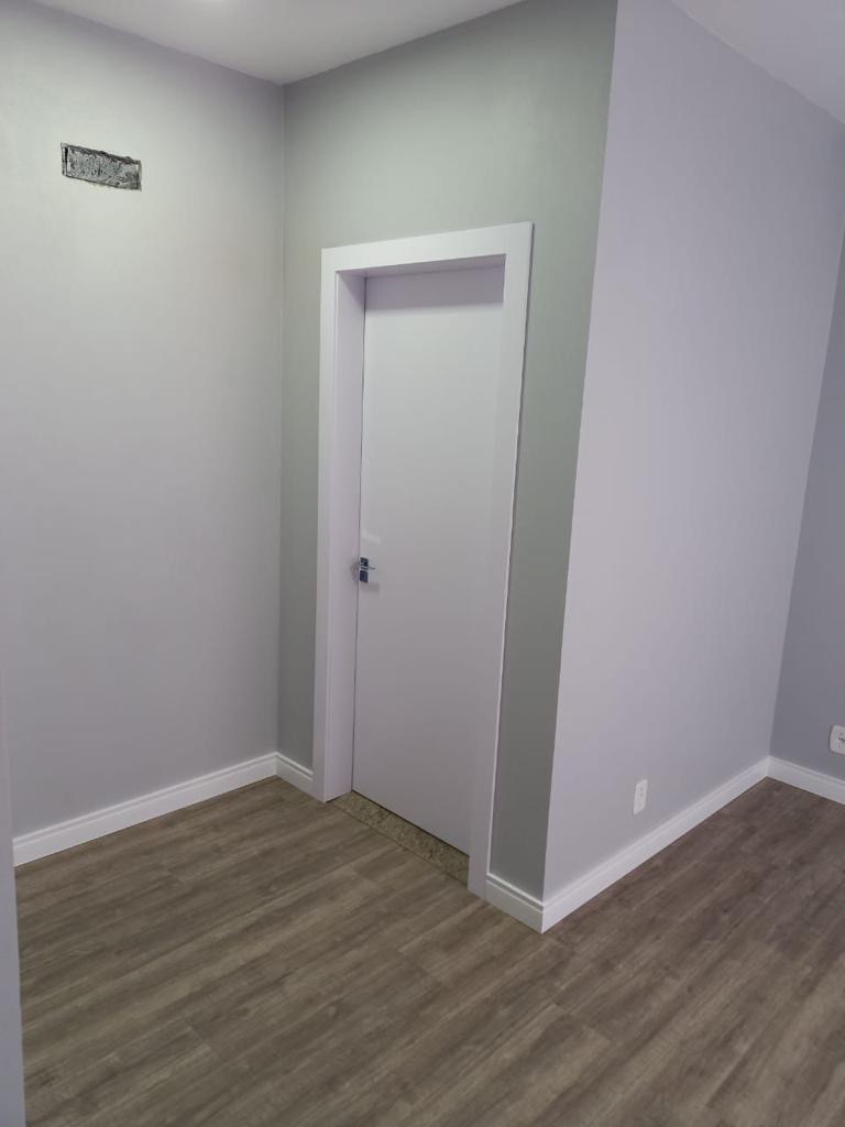 Porta branca com guarnição e rodapé instalados