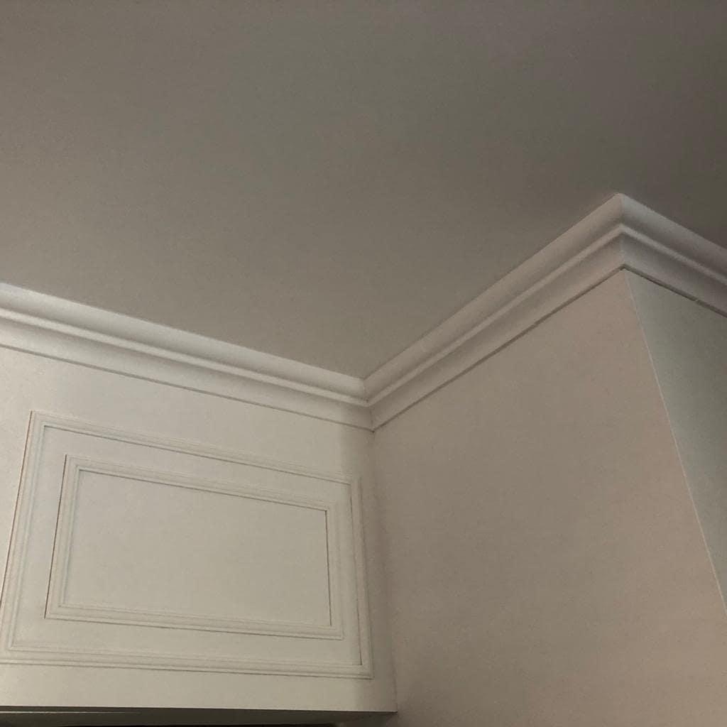 Boiserie com moldura de teto em canto de ambiente