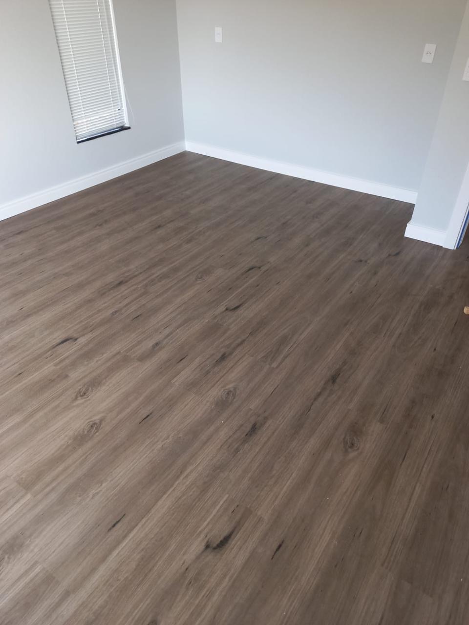 Piso vinílico escuro instalado em quarto