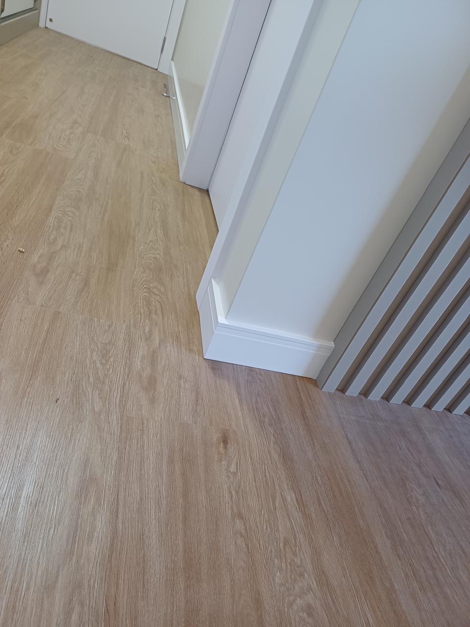 Rodapé alto branco ao lado de painel ripado
