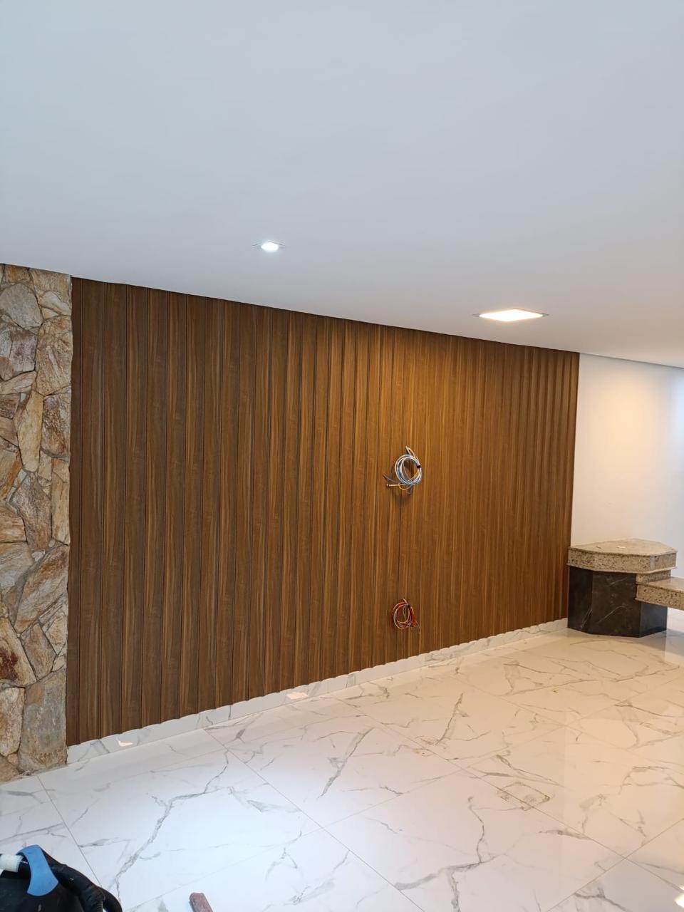 Parede revestida com painel ripado amadeirado