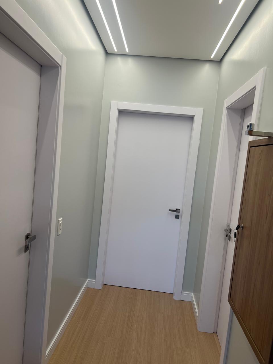 Portas brancas em corredor com iluminação em LED