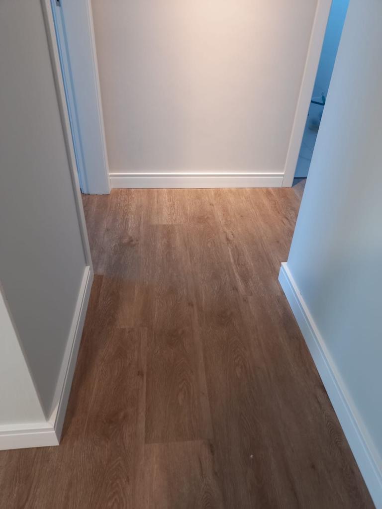 Piso e rodapé branco instalados em corredor