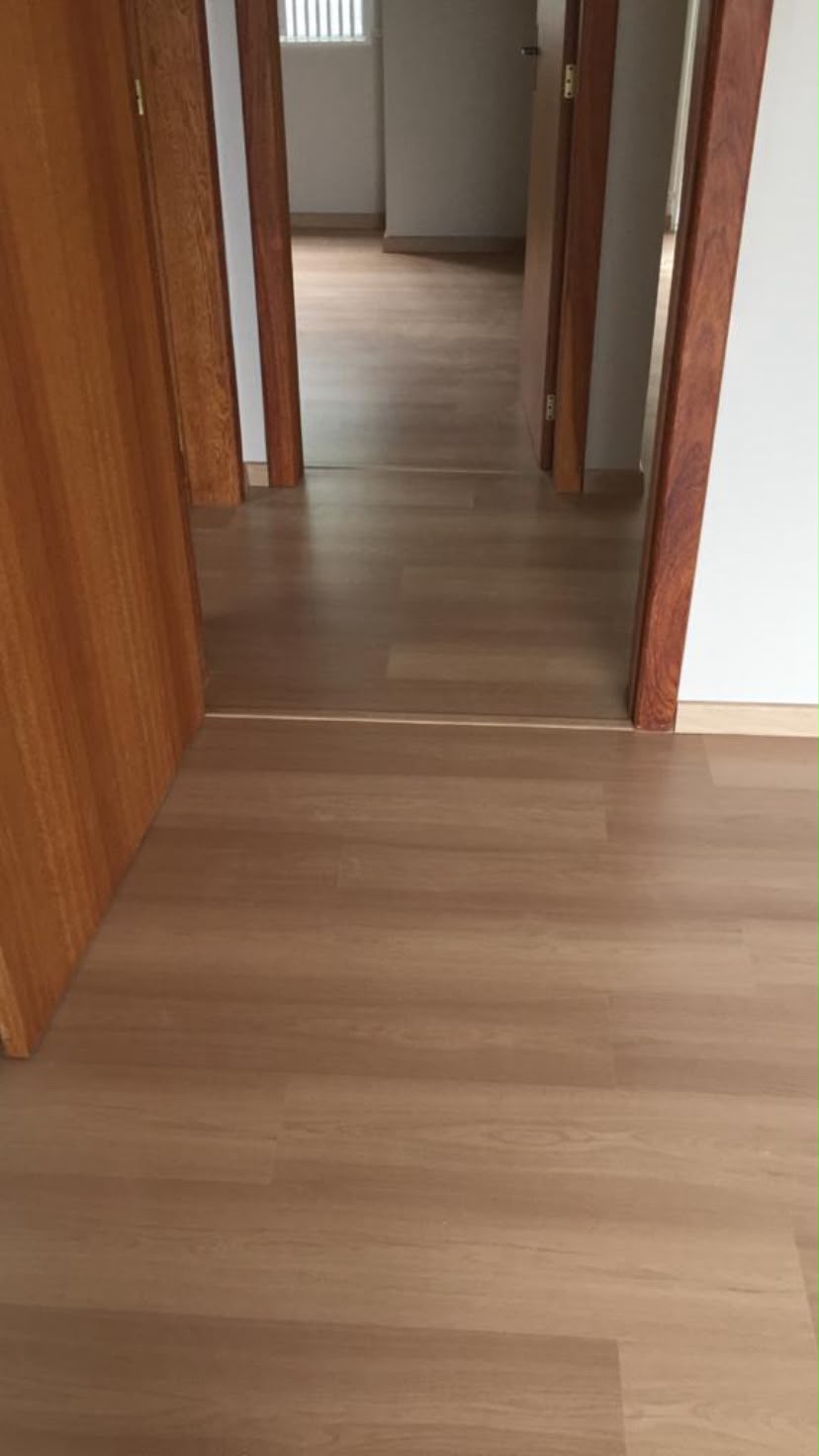 Piso laminado em corredor com portas de madeira