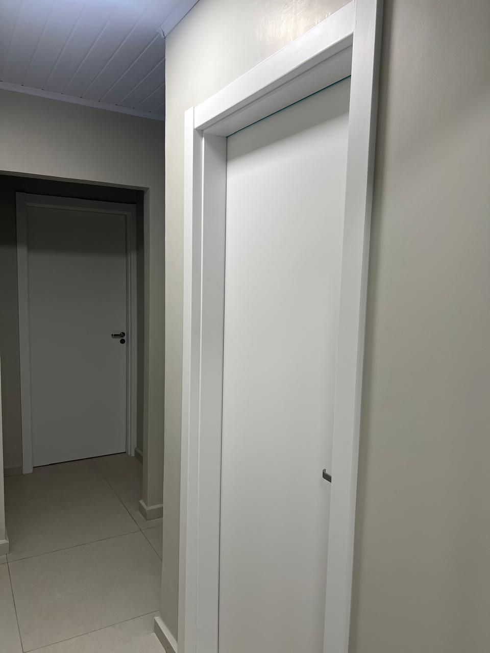 Portas brancas com guarnição em corredor